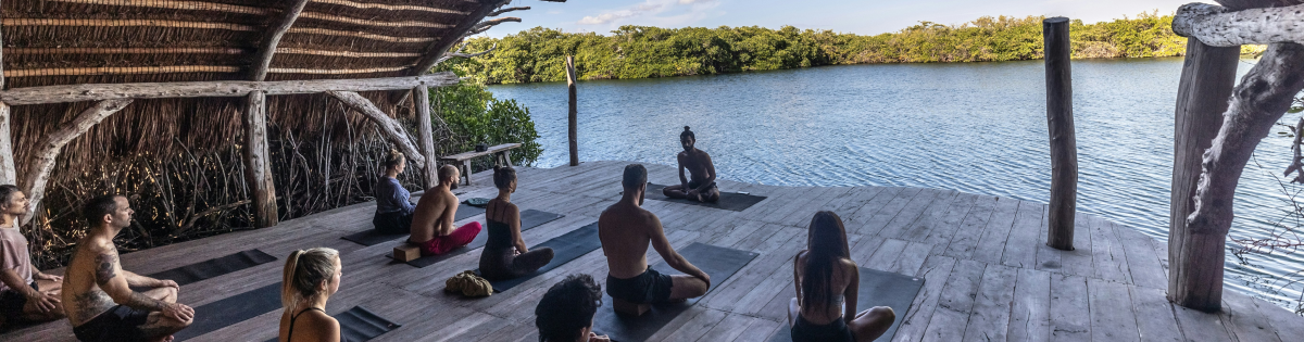 a woman is doing some yoga on the beach in the morning in Spain as she started organizing her own yoga classes in Spain by following our complete guide from creation to promotion.